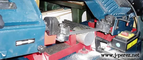 La imagen muestra una sierra de cinta cortado una barra de aluminio
